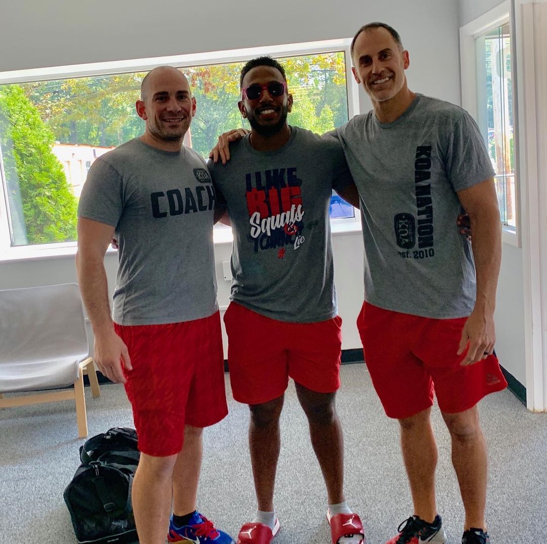 leg swings during fitness training three men standing together